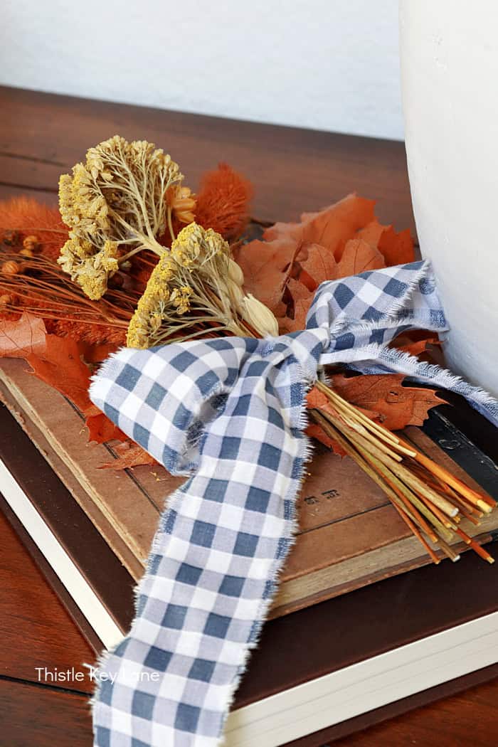 Dried floral bouquet with gingham ribbon. Early Fall Entry Table With Greenery.