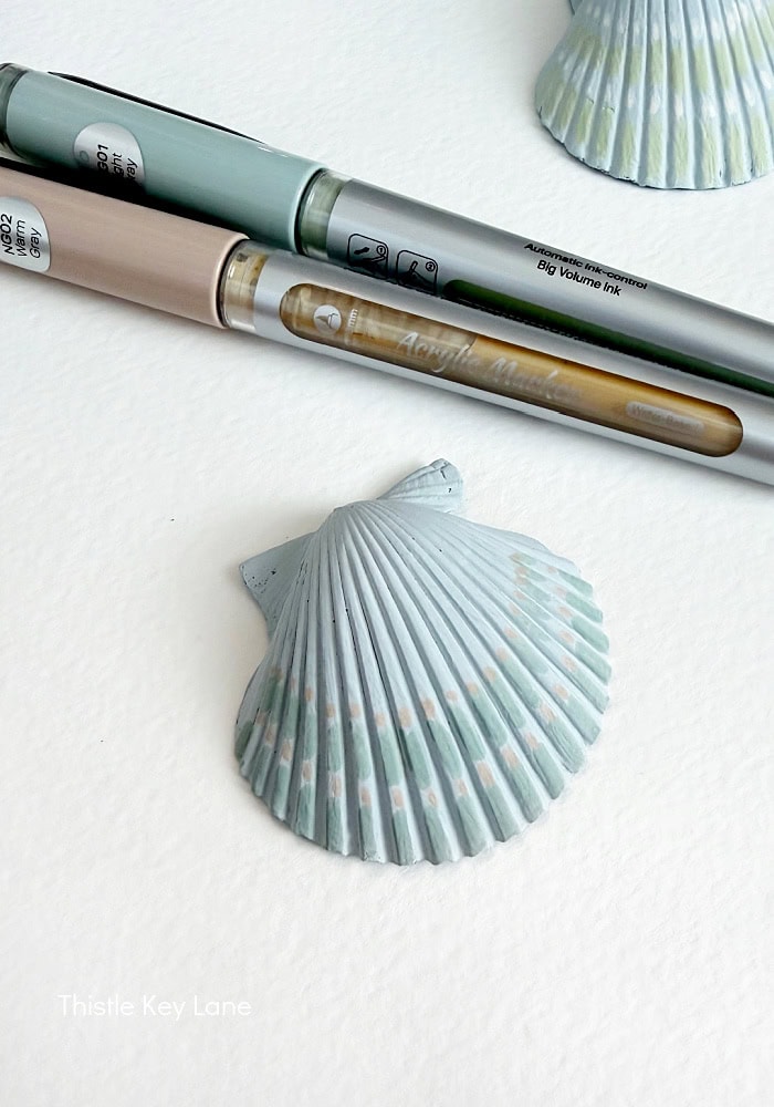 Shell details highlighted with paint pens. DIY Painted Shell Artwork.