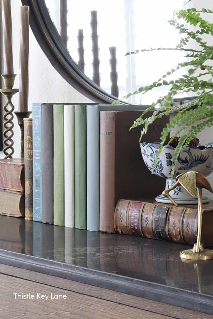 Books in shades of brown, green, blue and cream. Summer To Fall Sideboard Styling.