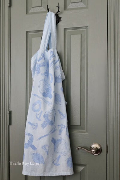 Apron hanging on a door hook. DIY Vegetable Stamped Apron.