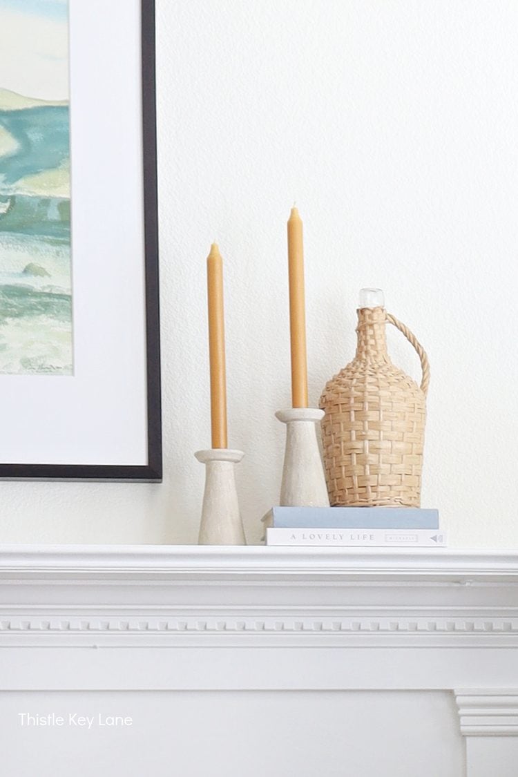 Yellow candles in ceramic holder and a wicker bottle. Mixing In Cozy Fall Decor.
