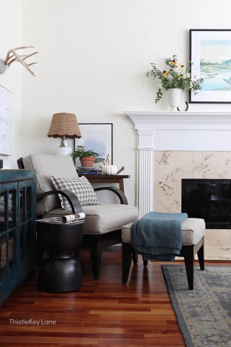 Arm chair, ottoman, throw blanket and fireplace.