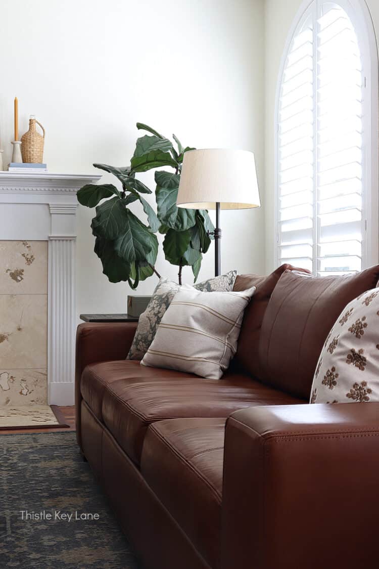 Leather sofa with pillows and large windows. Mixing In Cozy Fall Decor.