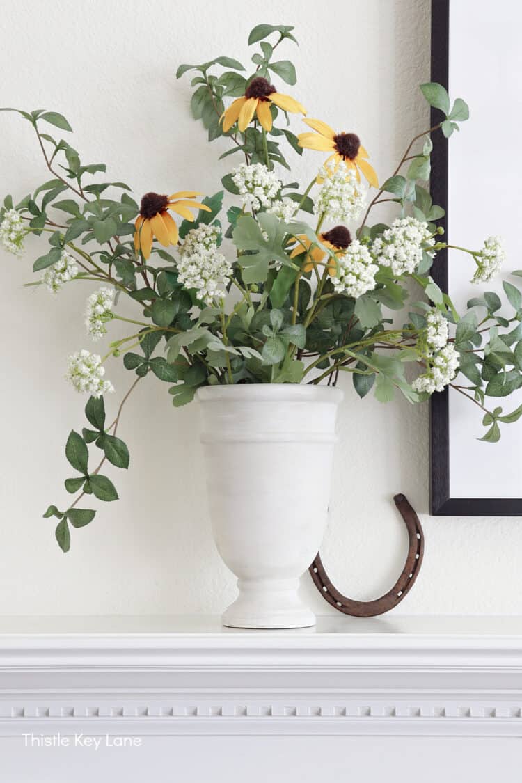 Faux leaves and flowers in a cream vase. Mixing In Cozy Fall Decor.