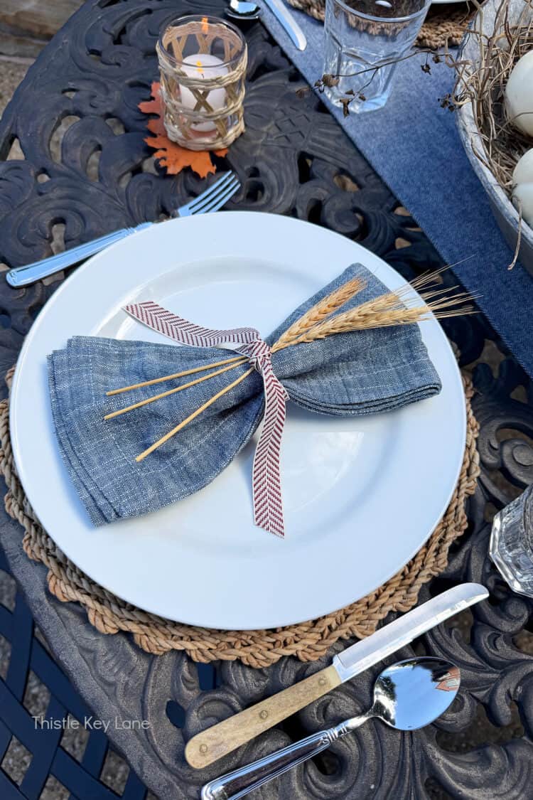 Fall table setting with wheat stocks and ribbon.